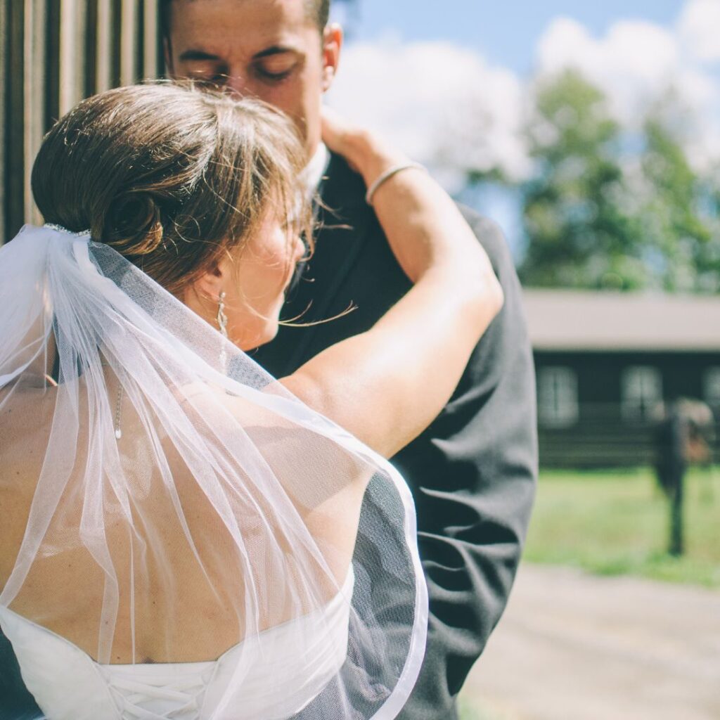 bride and groom embrace outside in sunshine