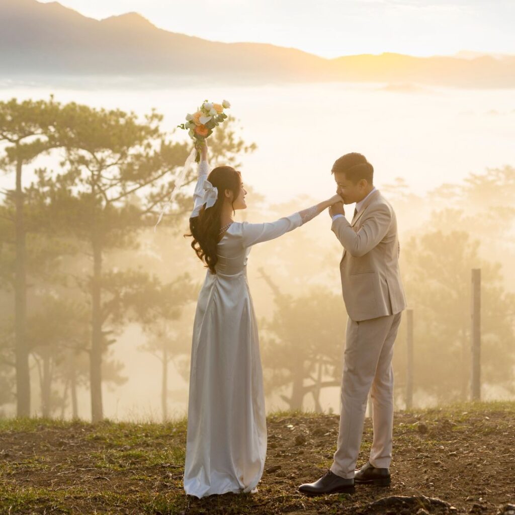 bride and groom stand in front of mountain scenery